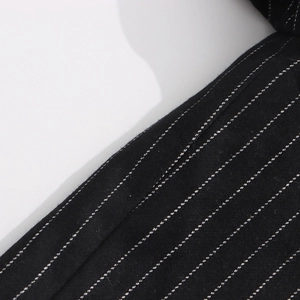 Close-up of black blazer fabric featuring white pinstripe texture and fine weaving details
