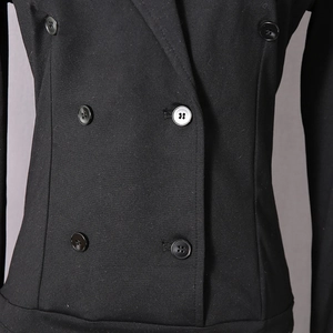 Detailed close-up of the double-breasted buttons and tailored waist on this black bodysuit