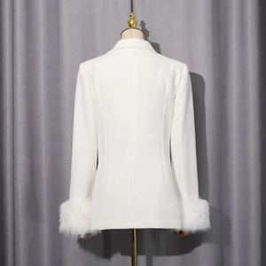 Vue arrière d'un blazer blanc ajusté avec d'élégantes finitions en fausse fourrure aux poignets