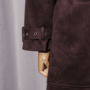 Detail of dark brown suede coat cuff with metallic buckle and soft brushed texture