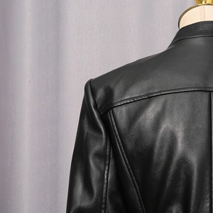 Detailed view of stitching and leather texture on a black jacket's shoulder and back