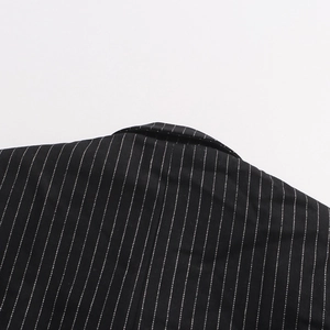 Close-up of black pinstripe blazer fabric showing clean neckline and high-quality texture