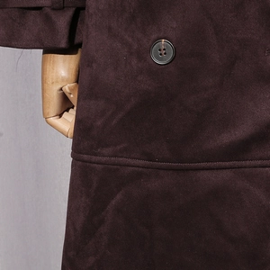 Detail of dark brown faux suede trench coat featuring resin buttons and precise stitching