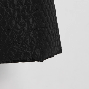 Detailed close-up of premium black quilted fabric featuring classic diamond patterns