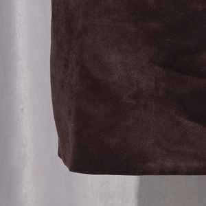 Detailed close-up of dark burgundy faux suede fabric texture and matte finish