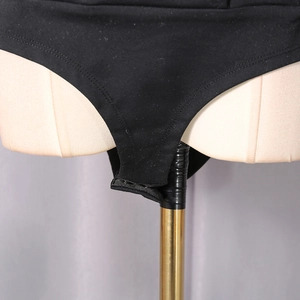 Detail view of the sleek black bodysuit featuring functional bottom snap closures