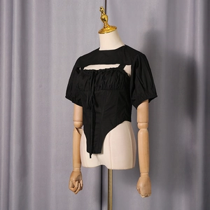 Detail of black two-piece set featuring corset-style camisole and short-sleeved crop top