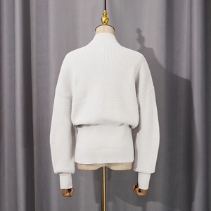 Rear view of white rib-knit sweater featuring batwing sleeves and wide hem