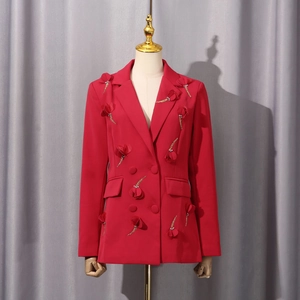 Detail eines roten Doppelreiher-Blazers mit 3D-Blumen und goldenen Quasten-Fransen