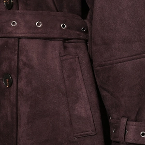 Detail of burgundy suede coat featuring large buttons, metal eyelet belt and refined texture
