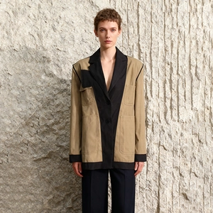 Detail of color-block khaki and black blazer featuring multi-pockets and premium tailoring