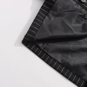 Detailed macro view of black pinstripe blazer fabric with lining and dark button