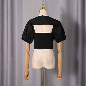Detail of black puff sleeve top featuring back cutout and smocked elastic texture