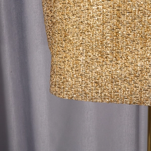 Close-up of luxury gold tweed fabric with delicate sequins on stylish jacket