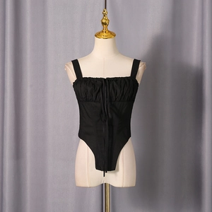 Detail of black camisole with pleated bust, drawstring tie and irregular fishbone hemline