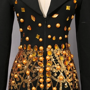Detailaufnahme der aufwendigen Goldperlen und Pailletten auf dem schwarzen Kleid