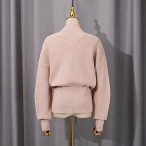 Close-up of pink knit sweater showing vertical ribbing texture and drop shoulder design