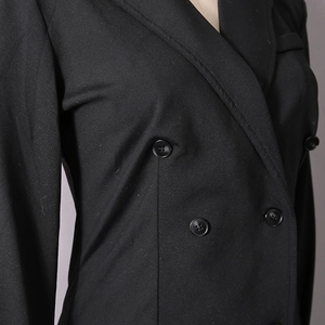 Detailed close-up of double-breasted black blazer with peak lapels and slim fit tailoring