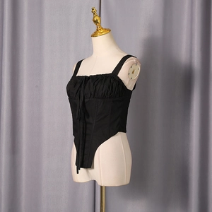 Side view of black corset top with halter neck and V-shaped hem on white mannequin