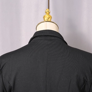 Detail view of the elegant suit collar and back seam stitching on a slim black bodysuit