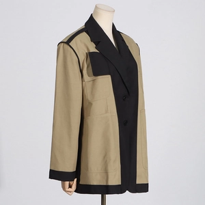 Detail view of khaki blazer featuring black contrast lapels and structured multi-pocket design