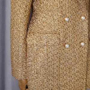 Detail of gold tweed blazer with pearl buttons and double-breasted design