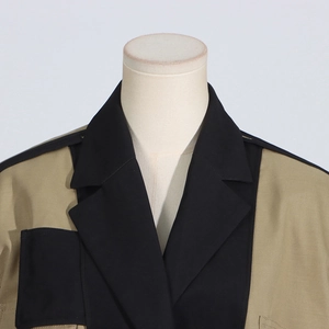 Detail of contrast lapels and shoulder straps on a khaki and black blazer