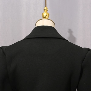Detailansicht der Rückseite von Kragen und Schulter des schwarzen Langarmkleides mit Fransen
