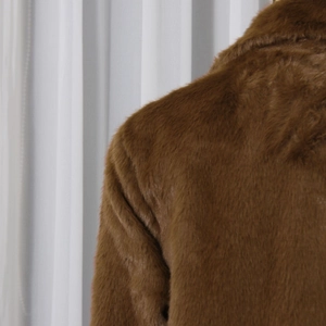 Close-up of the shoulder and back details on this brown faux fur wool coat