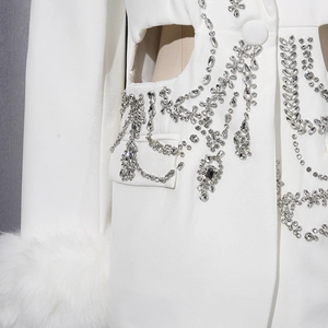 Détail de blazer blanc avec franges en cristal et poignets en fausse fourrure chic