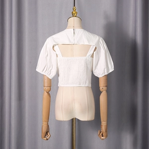 Detailed back view of white puff sleeve top with elastic shirring and metal zipper