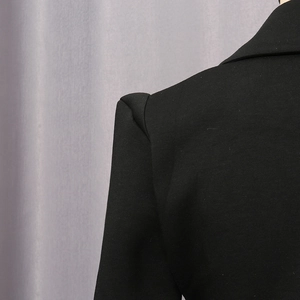 Detailansicht der strukturierten Schulterpartie und Stofftextur einer schwarzen Blazerjacke