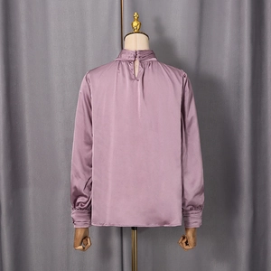 Vue détaillée du dos d'un chemisier en satin violet avec boutons au col et poignets plissés