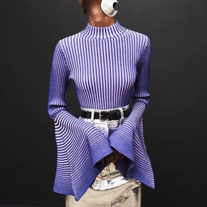Dettaglio del top in maglia a coste viola con maniche a campana e design a collo alto