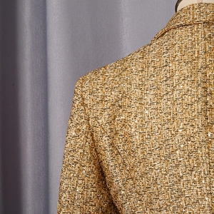 Detail of gold tweed fabric with sequins on premium French style tailored blazer