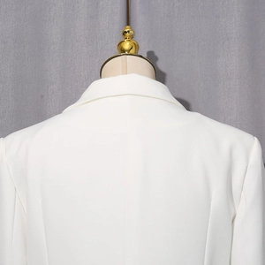 Détail du col de la veste blanche et de la texture des épaules avec strass élégants