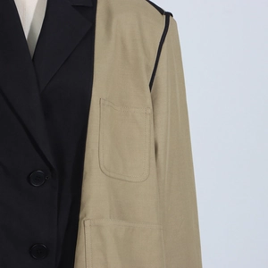 Close-up of contrast stitching detail and pocket on asymmetrical patchwork blazer