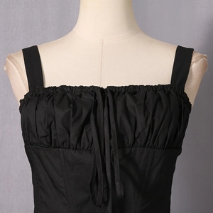 Detail view of the black camisole featuring ruched bust and delicate ribbon tie front