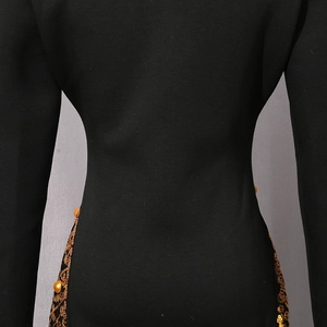 Detailansicht des schwarzen Langarmkleides mit goldener Spitze, Pailletten und Perlen