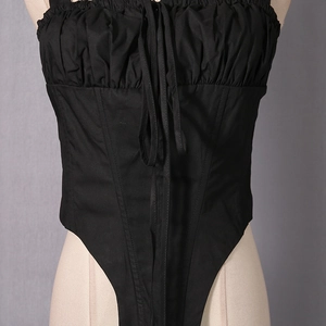 Detail of black corset style camisole with front drawstring and pointed hemline