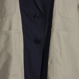 Detail of color-block jacket showing large patch pockets and contrast stitching texture