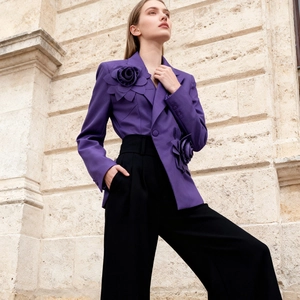Detailed close-up of 3D layered floral appliques on deep purple blazer jacket