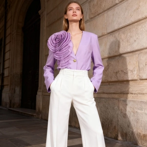 Detail of a light purple blazer featuring a 3D floral accent on the shoulder with a deep V-neck
