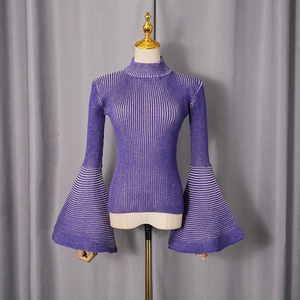 Dettaglio del top in maglia a coste viola con polsini a campana a righe e vestibilità slim