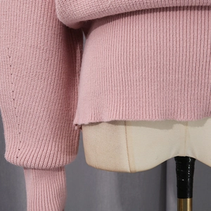 Close-up of pink knit sweater showing chunky rib texture on waist and cuff