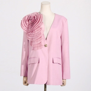 Detail of elegant pink blazer with oversized 3D pleated rose on shoulder and gold button