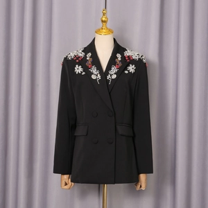 Detailansicht der aufwendigen Blumenstickerei und Perlenarbeit auf schwarzem Blazer
