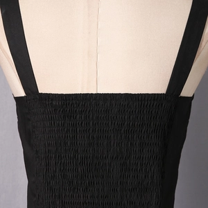 Close-up of black camisole top featuring elastic smocking detail and wide straps