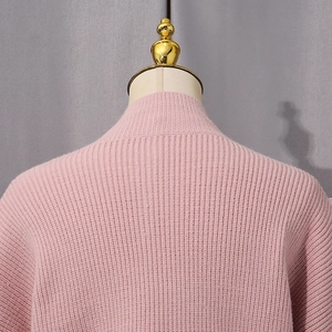 Close-up of pink ribbed knit sweater with a cozy mock neck and soft vertical textures