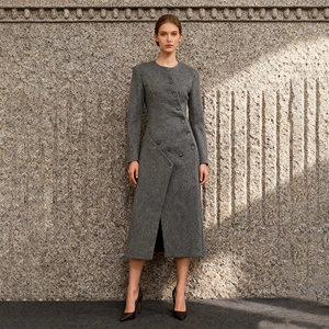 Detail of grey wool coat featuring unique asymmetrical diagonal button closure and round neck